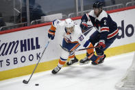 New York Islanders left wing Anders Lee (27) skates with the puck past Washington Capitals defenseman Justin Schultz (2) during the second period of an NHL hockey game Tuesday, Jan. 26, 2021, in Washington. (AP Photo/Nick Wass)