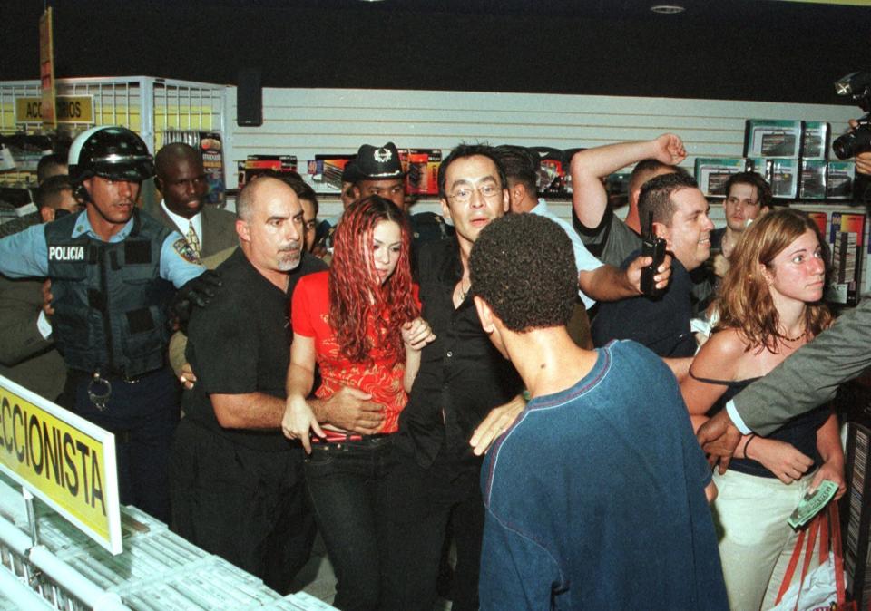 Shakira was a huge Latin American star by 1999 and everyone wanted to meet the rock artist.   Here she is being escorted by bodyguards and police officers through La Gran Discoteca record store in San Juan, Puerto Rico Thursday, July 1, 1999. Approximately 1,000 fans had mobbed the store in an attempt to get an autograph.