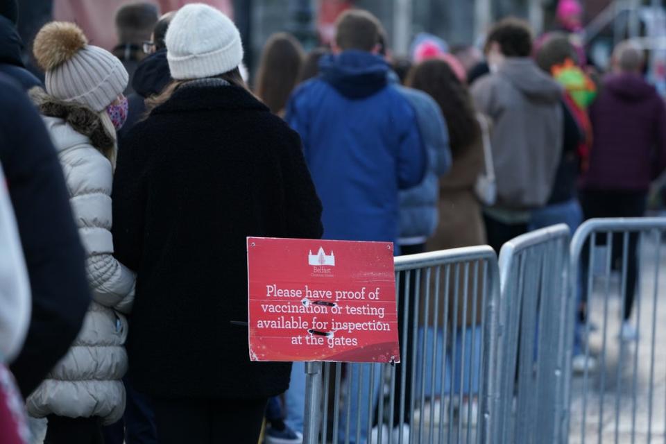 People queue to show Covid certificates to enter the Christmas market outside Belfast City Hall (Brian Lawless/PA) (PA Wire)