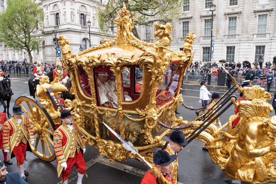 King Charles and Queen Camilla ride in the Gold State Coach after the coronation.