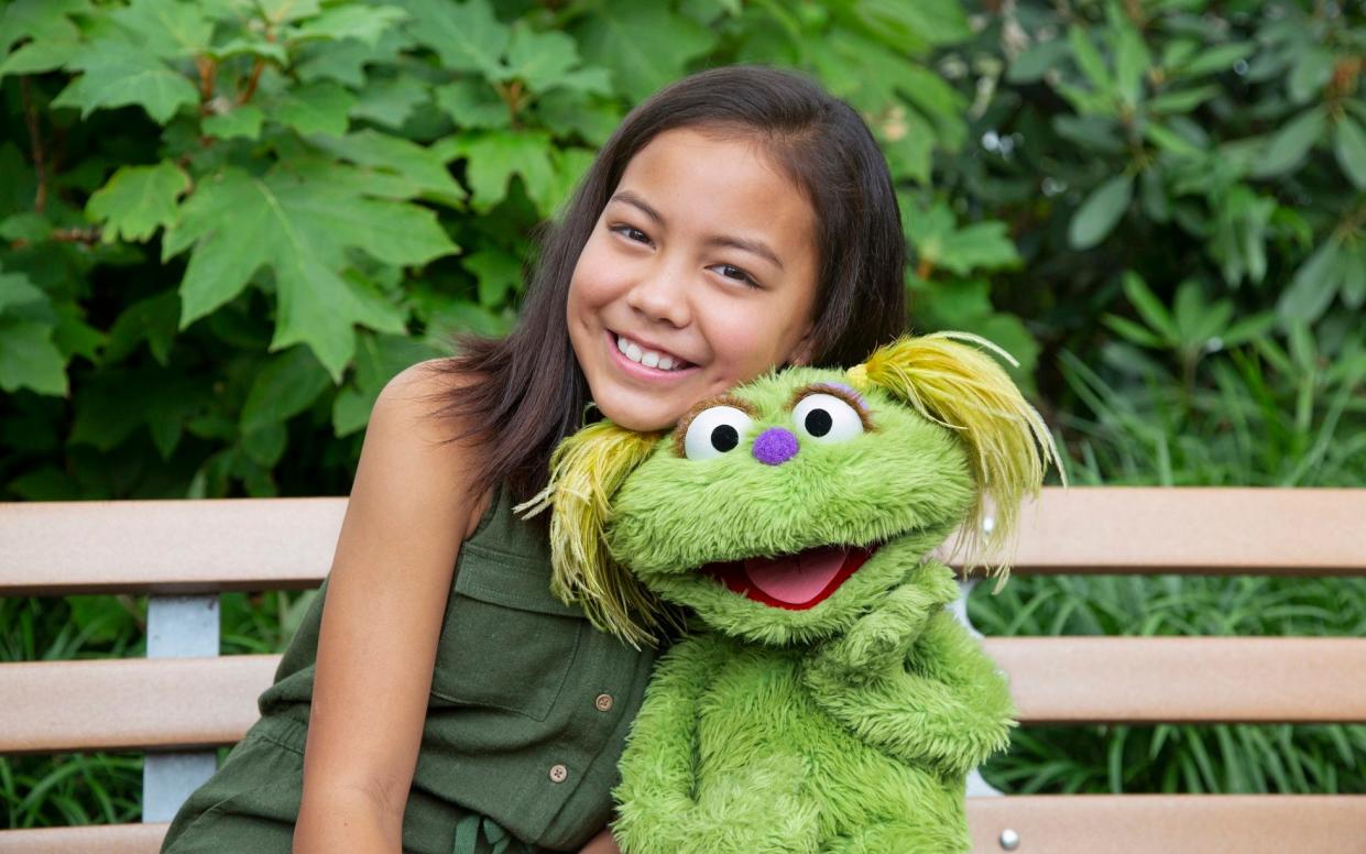 10-year-old Salia Woodbury with Sesame Street character Karli - Sesame Workshop