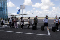 Passengers walk with a social distancing on their arrival at Bali airport, Indonesia on Friday, July 31, 2020. Indonesia's resort island of Bali reopened for domestic tourists after months of lockdown due to a new coronavirus. (AP Photo/Firdia Lisnawati)