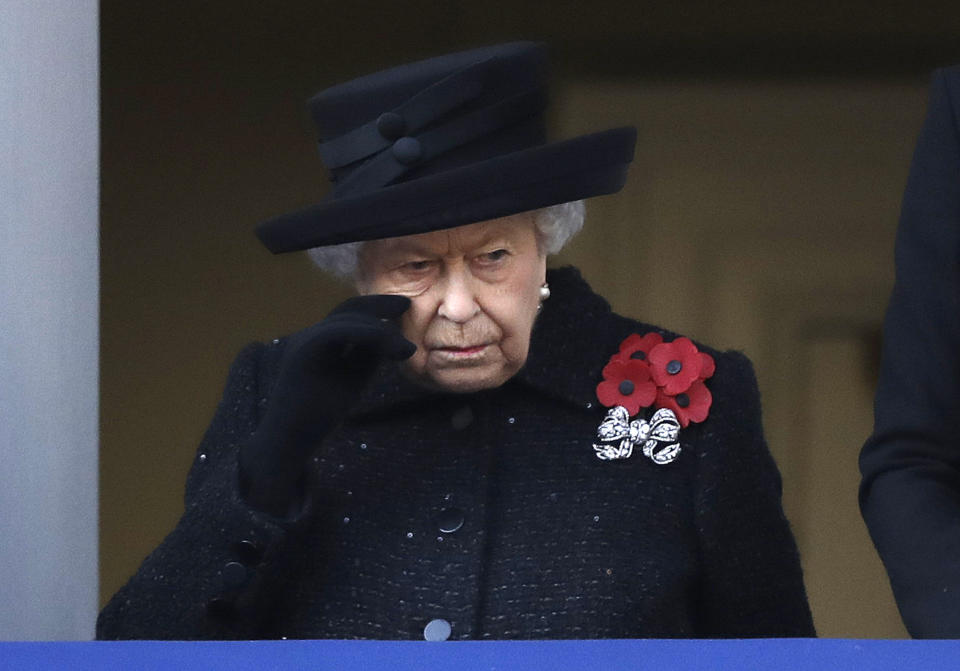 Britain's Queen Elizabeth II wipes her cheek as she watches the Remembrance Sunday ceremony at the Cenotaph in Whitehall in London, Sunday, Nov. 10, 2019. Remembrance Sunday is held each year to commemorate the service men and women who fought in past military conflicts. (AP Photo/Matt Dunham)