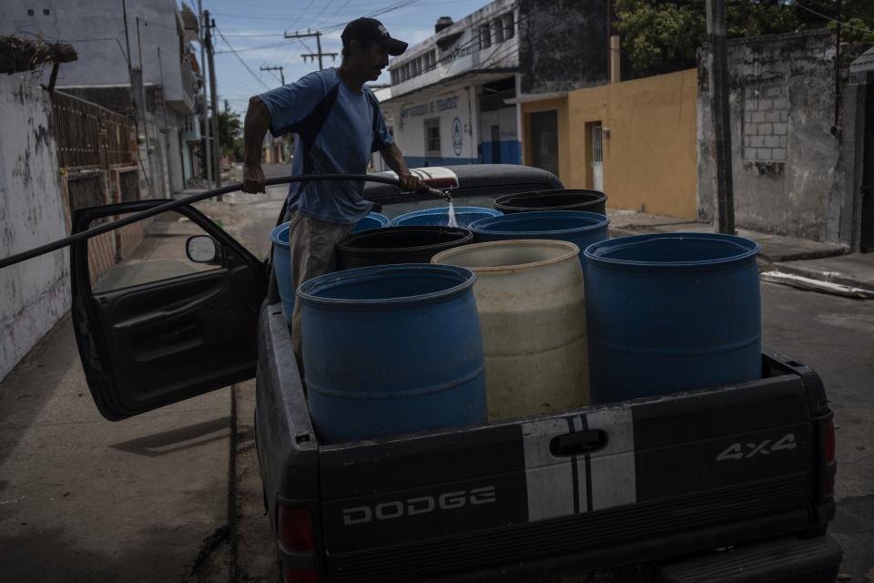 Un hombre llena bidones con agua debido a la escasez causada por las altas temperaturas y la sequía en Veracruz, México, el 16 de junio de 2024. El cambio climático provocado por la humanidad subió el termostato y multiplicó las posibilidades de que se produjera el letal calor que ha castigado este mes el suroeste de Estados Unidos, México y Centroamérica, según un nuevo estudio rápido publicado el jueves 20 de junio de 2024. (AP Foto/Félix Márquez)