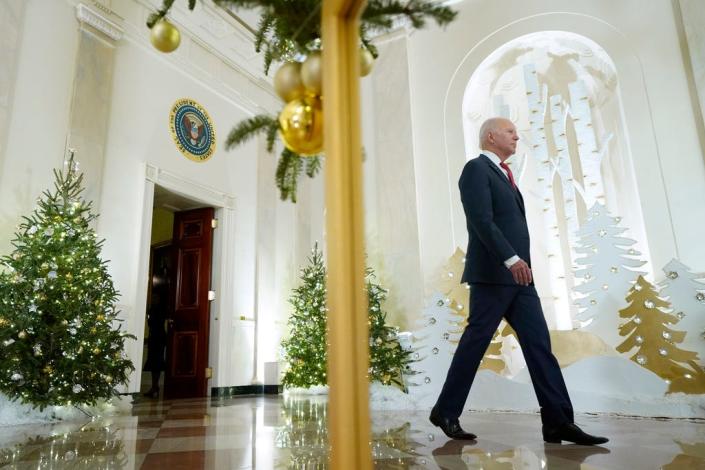 پرزیدنت جو بایدن در حالی که به سمت اتاق شرقی کاخ سفید می رود تا در آستانه تعطیلات، پنجشنبه، 22 دسامبر 2022، در واشنگتن سخنرانی کند، در آینه منعکس می شود.