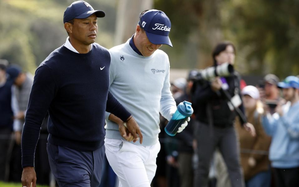 Tiger Woods de los Estados Unidos (L) y Justin Thomas de los Estados Unidos salen del noveno tee durante la primera ronda del The Genesis Invitational en el Riviera Country Club - Cliff Hawkins/Getty Images