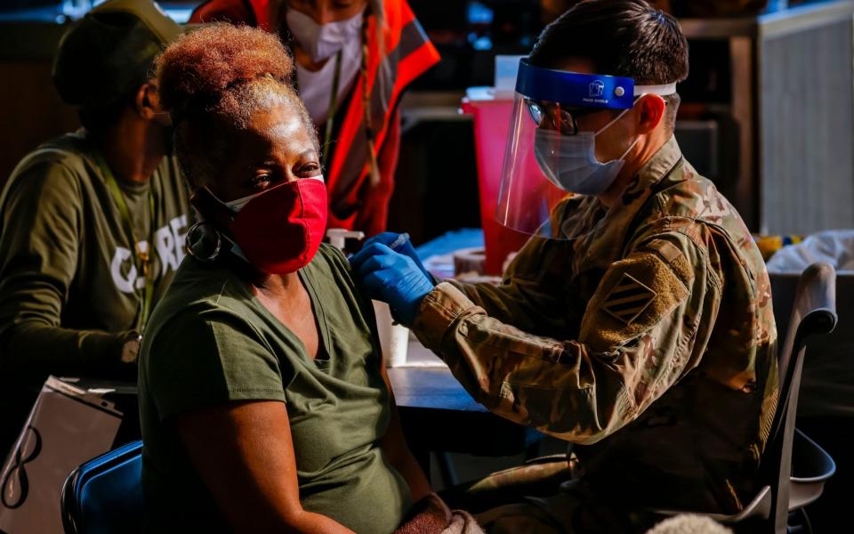 A US Army medic administers a shot to a patient at the Mercedes-Benz Stadium Community Vaccination Center, a jointly run Covid-19 mass vaccination site, in Atlanta, Georgia. The site has averaged more than 8,500 shots per day since its opening to the general public - ERIK S LESSER/EPA-EFE/Shutterstock 