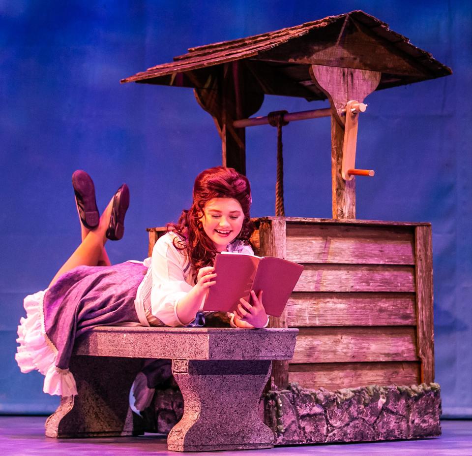 Belle, played by Adrienne Hebert, reads a book by the well during a dress rehearsal of "Beauty and the Beast" at the Ocala Civic Theatre. The show is onstage through June 5.