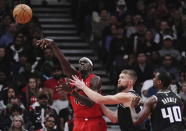 Toronto Raptors forward Pascal Siakam (43) passes as Sacramento Kings forward Domantas Sabonis (10) and forward Harrison Barnes (40) defend during second half of an NBA basketball game in Toronto on Wednesday, Dec. 14, 2022. (Nathan Denette/The Canadian Press via AP)