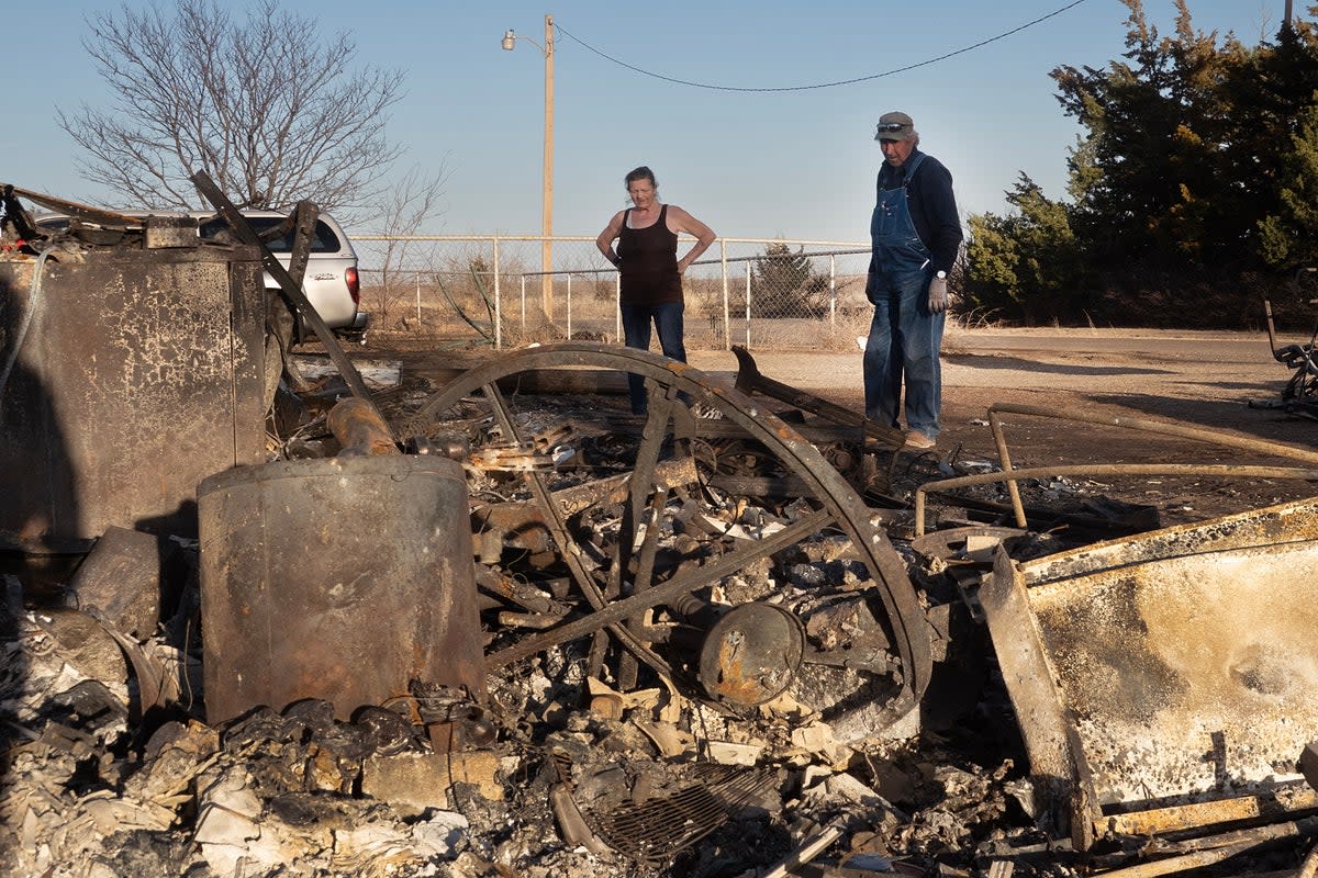 Vernon Jones helps his wife Melissa clean debris from her father's property after a garage and carport were destroyed by the Smokehouse Creek fire on March 03, 2024 near Stinnett, Texas. (Getty Images)