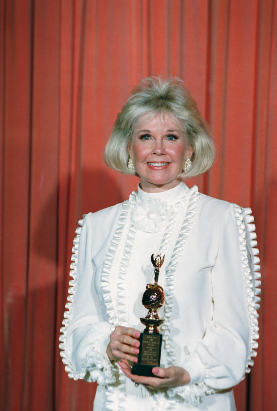 FILE - In this Jan. 28, 1989 file photo, actress and animal rights activist Doris Day poses with the Cecil B. DeMille Award she was presented with at the annual Golden Globe Awards ceremony in Los Angeles, Calif. Day is celebrating a landmark birthday with an auction to benefit her favorite cause: animals. A spokesman for Day said Tuesday, March 11, 2014, the nonprofit Doris Day Animal Foundation will mark her 90th birthday in April with a bash in Carmel, Calif. (AP Photo, file)