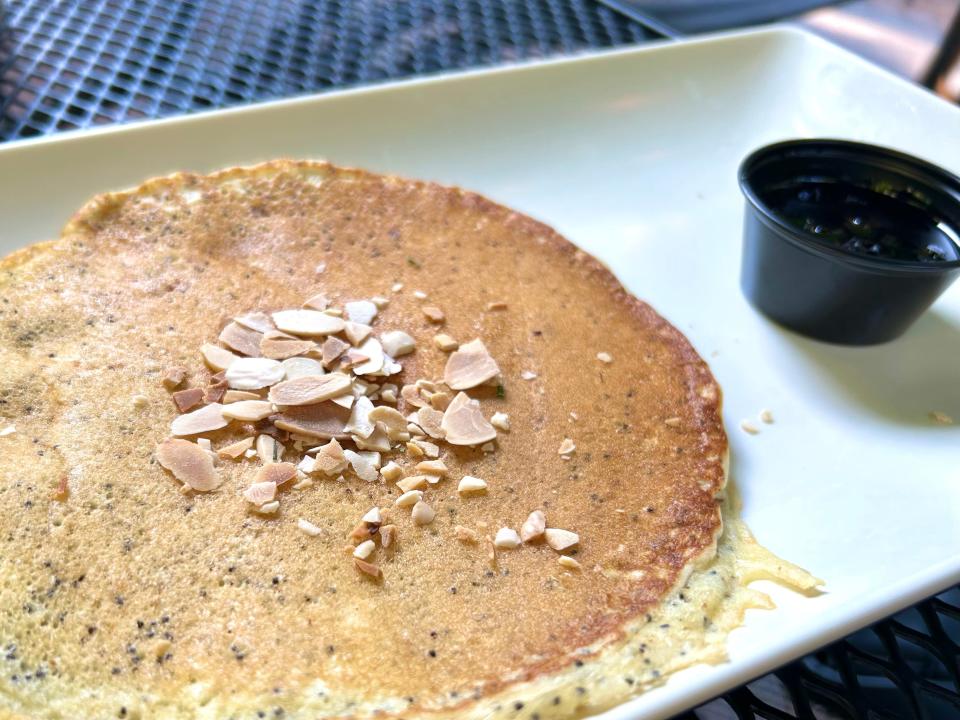 The lemon poppyseed pancake at Cafe at the Plaza is served with toasted almonds and a side of house-made blueberry-ginger syrup. The pancake can be ordered a la carte or as a stack.