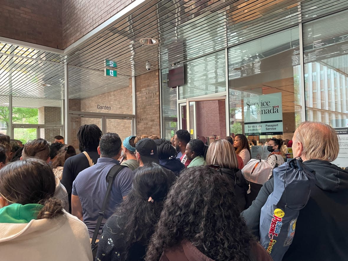 Hundreds of people throng the Service Canada passport office in Montreal Tuesday. Karina Gould, minister of Families, Children and Social Development, said there have been lineups of 400 people there most days in recent weeks. (Jennifer Yoon/CBC - image credit)