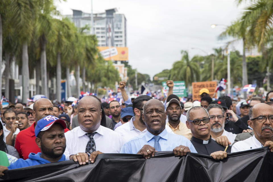 People protest a constitutional reform that would allow President Danilo Medina a third term in office as they march in front of Congress in Santo Domingo, Dominican Republic, Wednesday, June 26, 2019. The proposal has provoked protests from Dominicans who call it backsliding on a young democracy that emerged from decades of brutal dictatorship. (AP Photo/Tatiana Fernandez)