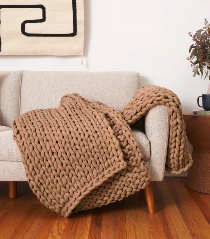 bearaby knit weighted blanket in brown on top of couch