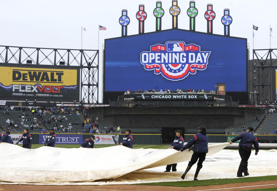 The grounds crew puts a tarp on the field at Guaranteed Rate Field during a rain delay before an MLB baseball game between the Chicago White Sox and Detroit Tigers on opening day Monday, April 3, 2017 in Chicago. (AP Photo/Paul Beaty)