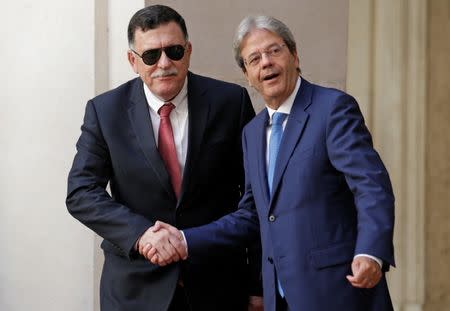 Italian Prime Minister Paolo Gentiloni (R) shakes hands with his Libyan counterpart Fayez al-Sarraj at Chigi Palace in Rome, Italy, July 26, 2017. REUTERS/Max Rossi