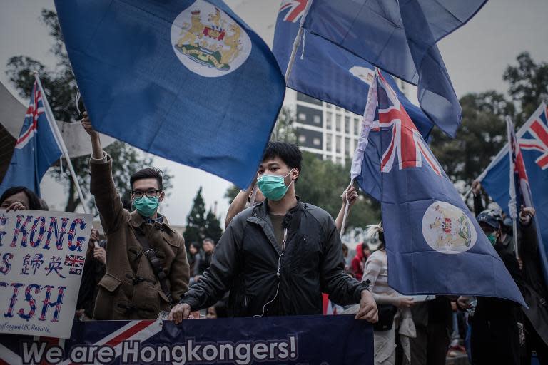 Demonstrators display colonial flags during a march for democracy in Hong Kong on February 1, 2015