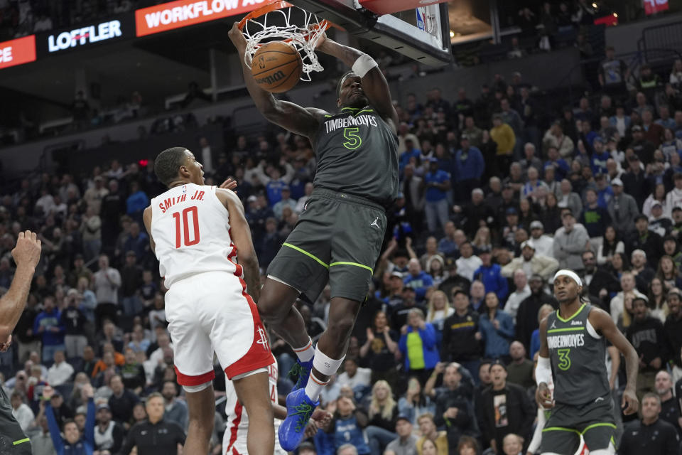 Minnesota Timberwolves guard Anthony Edwards (5) dunks against Houston Rockets forward Jabari Smith Jr. (10) during the second half of an NBA basketball game, Tuesday, April 2, 2024, in Minneapolis. (AP Photo/Abbie Parr)