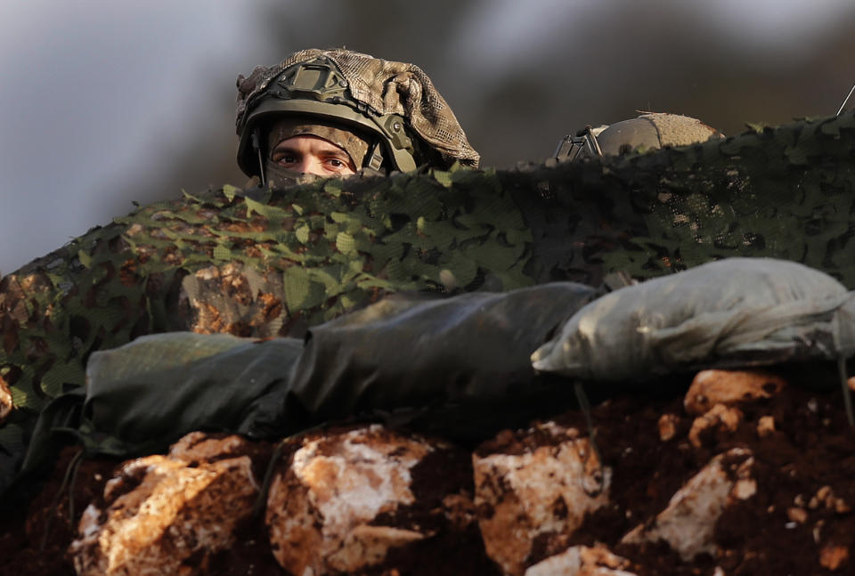 In this Thursday, Dec. 13, 2018 photo, an Israeli soldier looks out from one of their new positions, near the southern border village of Mays al-Jabal, Lebanon. As Israeli excavators dig into the rocky ground, Lebanese across the frontier gather to watch what Israel calls the Northern Shield operation aimed at destroying attack tunnels built by Hezbollah. But Lebanese soldiers in new camouflaged posts, behind sandbags, or inside abandoned homes underscore the real anxiety that any misstep could lead to a conflagration between the two enemy states that no one seems to want. (AP Photo/Hussein Malla)