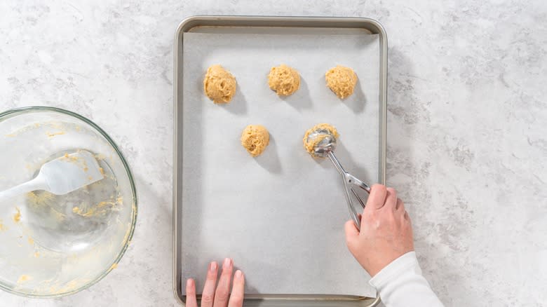 Scooping cookie dough on pan