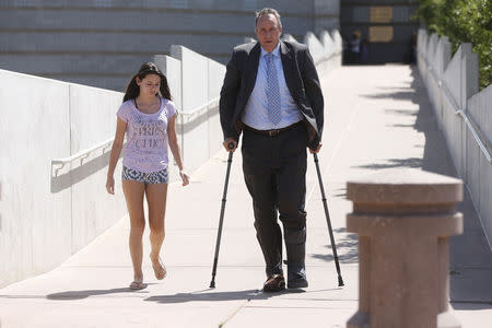 Former Attorney General Mark Shurtleff walks with his daughter Annie Shurtleff as he leaves after being booked at the Salt Lake County Metro Jail in South Salt Lake City July 15, 2014. REUTERS/Jim Urquhart
