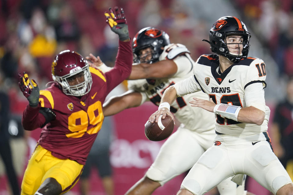 Oregon State quarterback Chance Nolan, right, throws as Southern California linebacker Drake Jackson (99) closes in during the first half of an NCAA college football game Saturday, Sept. 25, 2021, in Los Angeles. (AP Photo/Marcio Jose Sanchez)