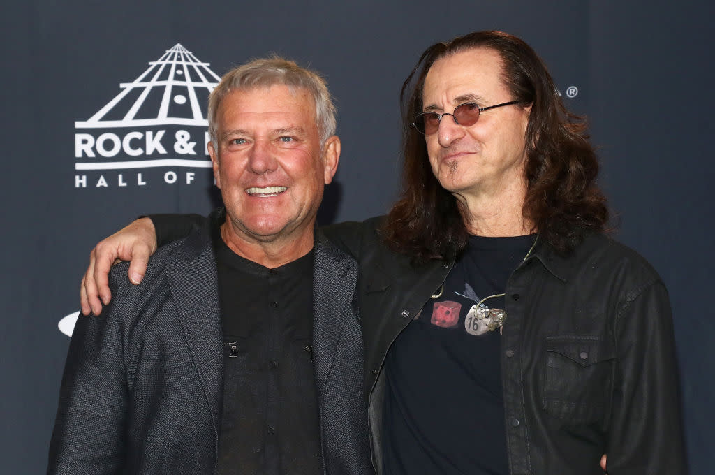  A picture of Alex Lifeson and Geddy Lee posing for photographers. 