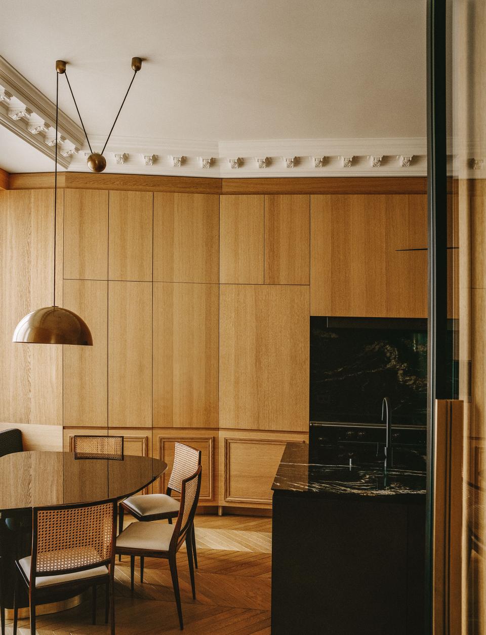 In the kitchen, Geraldo de Barros chairs cluster around a table designed by Stanislas; 1980s ceiling lamp by Florian Schulz.