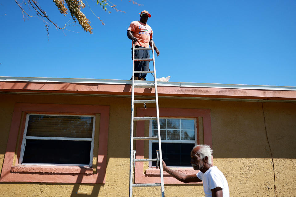 Johnny Lee Kerney and Francisco Mancheo fix a roof on a damaged home in Fort Myers, Fla., on Oct. 7, 2022.<span class="copyright">Joe Raedle—Getty Images</span>