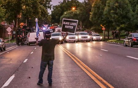 A man holds a sign during a demonstration after a shooting incident in St. Louis, Missouri August 19, 2015. REUTERS/Lawrence Bryant