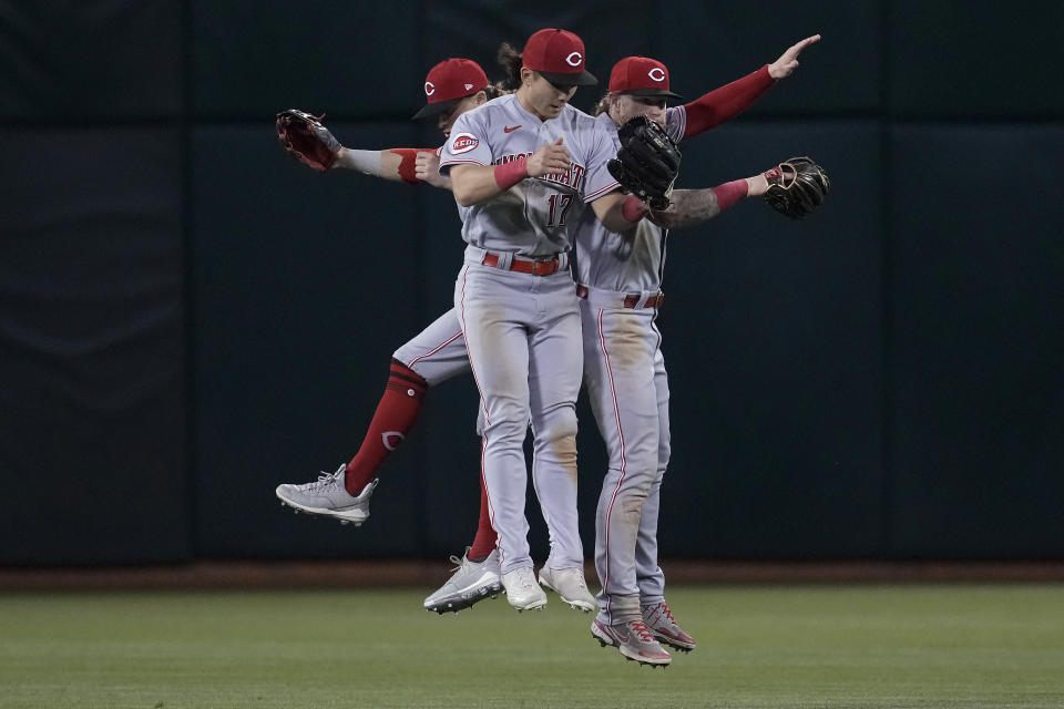 Cincinnati Reds' TJ Friedl, left, Stuart Fairchild, middle, and Jake Fraley celebrate the team's win over the Oakland Athletics in a baseball game in Oakland, Calif., Friday, April 28, 2023. (AP Photo/Jeff Chiu)