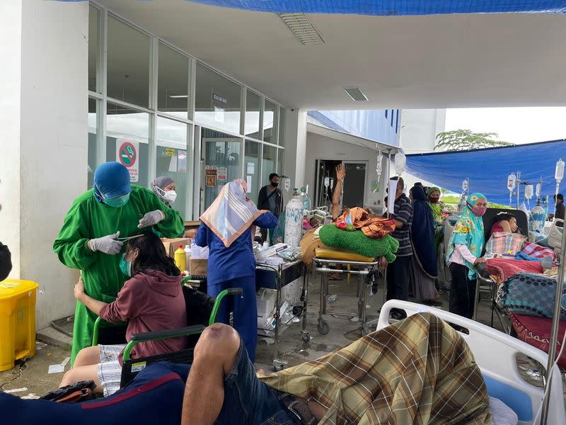 Injured people are seen outside an Emergency Room following an earthquake in Mamuju