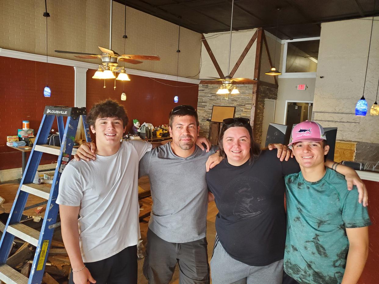 Josh Kirkman (second from left) and Jessie Kirkman (third from left) stand in the downtown Lexington property they bought in late July. The Guilford County couple who own a restaurant in Greensboro has plans to open a restaurant and family pool hall at the former Bella Villaggio Italian Restaurant in Lexington, possibly in 2024 after much renovation. They are pictured with sons Tristan and Rylee.