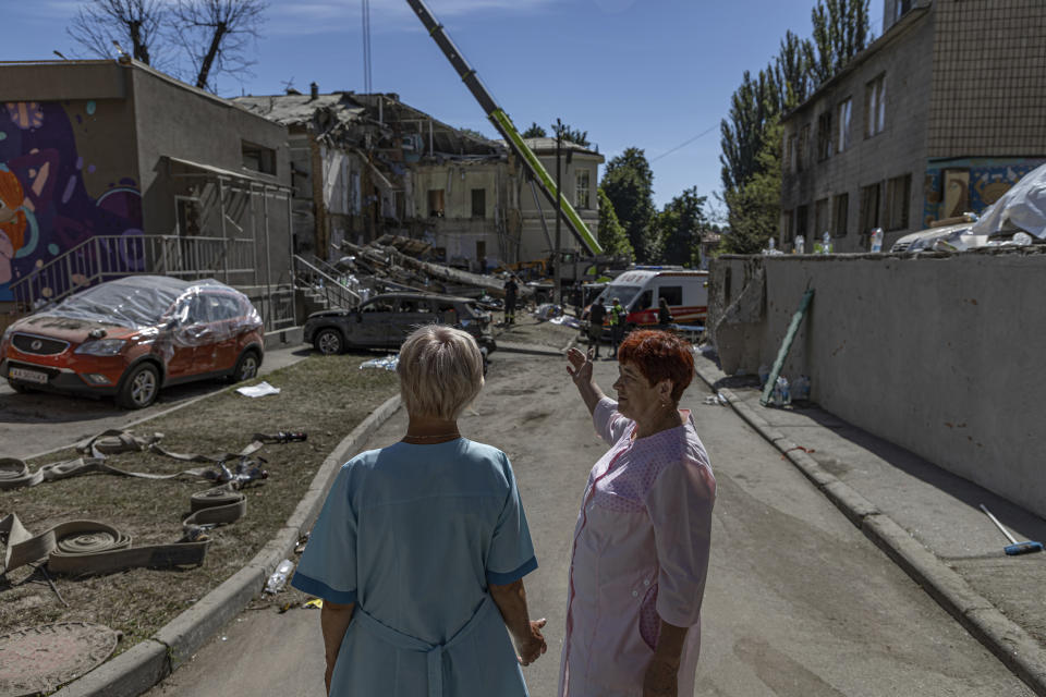 Hospital workers watch as rescue workers clear the rubble at the site of Okhmatdyt children's hospital hit by Russian missiles on Monday, in Kyiv, Ukraine, Tuesday, July 9, 2024. (AP Photo/Anton Shtuka)