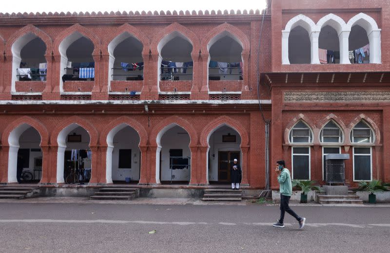 A man while talking on the phone walks past the boys' hostel inside the premises of Aligarh Muslim University (AMU) in Aligarh