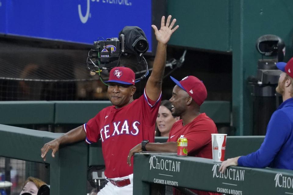 Texas Rangers third base coach Tony Beasley acknowledges cheers from fans during the second inning of the team's baseball game against the Oakland Athletics in Arlington, Texas, Friday, July 9, 2021. Fans cheered after an in-house announcement advising that Beasley would be throwing to Joey Gallo during the All-Star home run derby. (AP Photo/Tony Gutierrez)