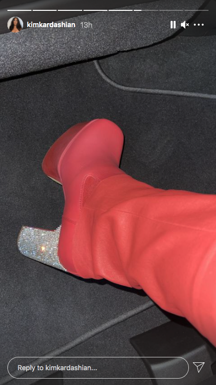 Kim Kardashian takes a picture of her red boots with sparkly heels at Kanye West's album listening event