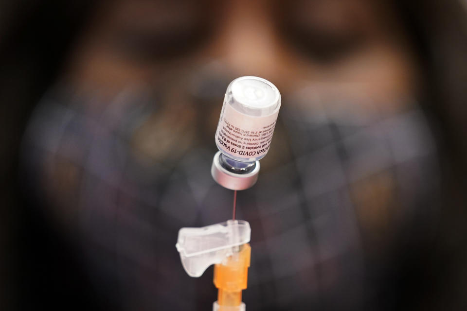 FILE - In this Jan. 22, 2021, file photo, Tina Killebrew, a certified medical assistant, prepares a dose of the Pfizer-BioNTech COVID-19 vaccine at a vaccination center at the University of Nevada, Las Vegas. The makers of COVID-19 vaccines are figuring out how to tweak their recipes against worrisome virus mutations — and regulators are looking to flu as a blueprint if and when the shots need an update. (AP Photo/John Locher, File)