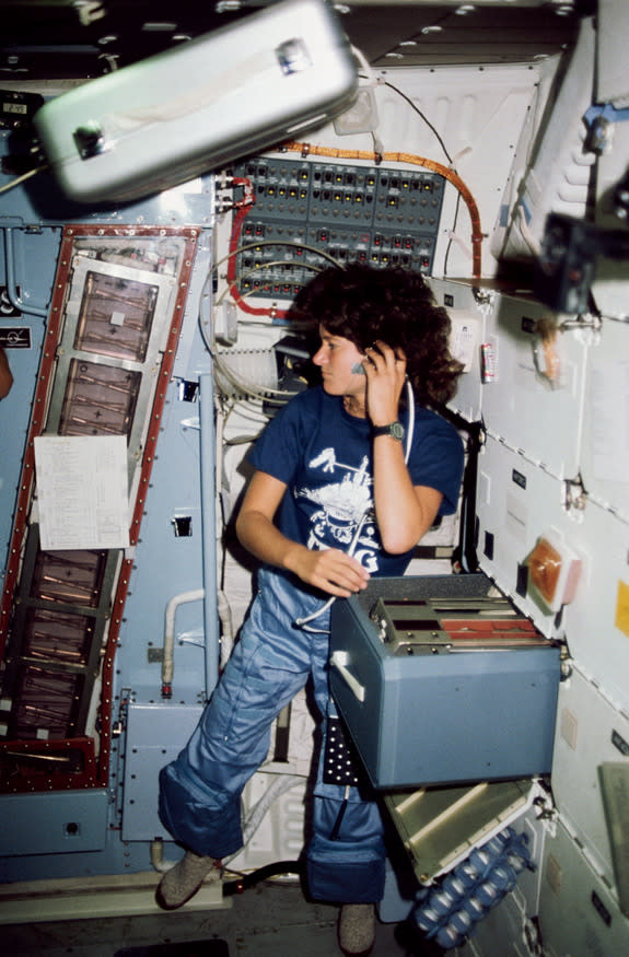 Astronaut Sally K. Ride, STS-7 mission specialist, communicates with ground controllers from the mid deck of the Earth-orbiting Space Shuttle Challenger. This image was taken in June 1983.