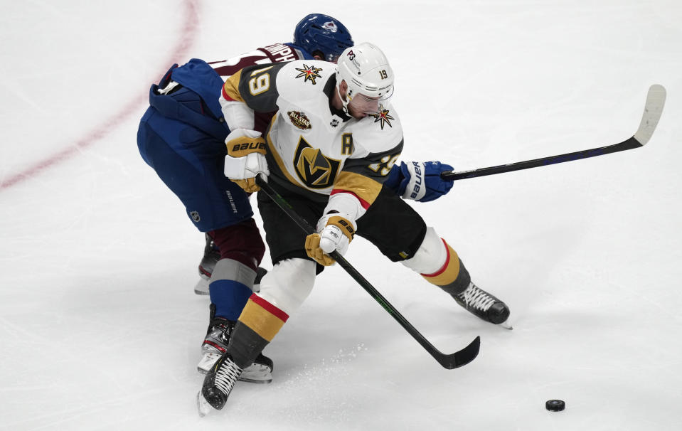 Vegas Golden Knights right wing Reilly Smith, front, is tied up by Colorado Avalanche left wing J.T. Compher in the first period of an NHL hockey game Tuesday, Oct. 26, 2021, in Denver. (AP Photo/David Zalubowski)