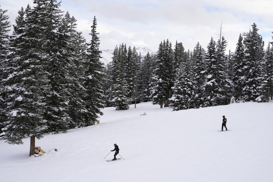 Skiers go down a hill at Aspen Mountain on Tuesday, Jan. 10, 2023, in Aspen, Colo. As global warming threatens to put much of the ski industry out of business over the next several decades, resorts are beginning to embrace a role as climate activists. (AP Photo/Brittany Peterson)