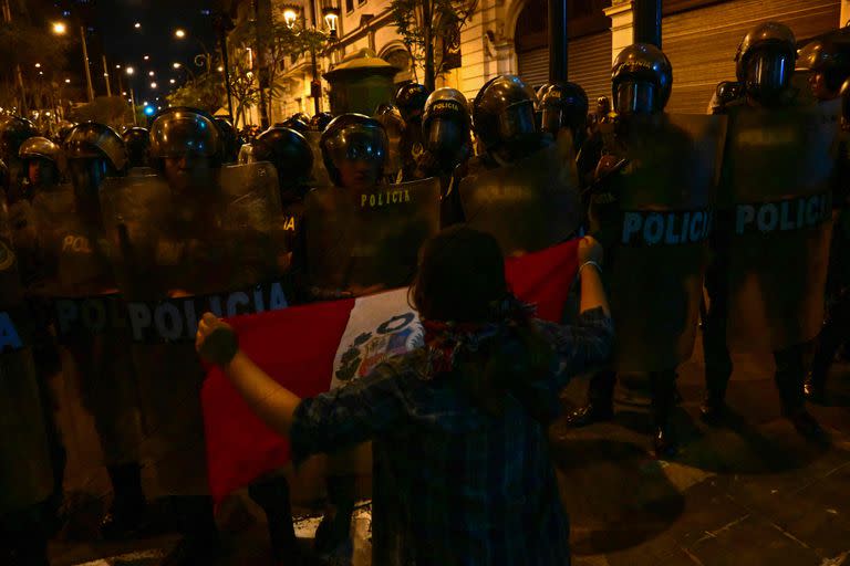 Un partidario del ex presidente Pedro Castillo grita a la policía antidisturbios mientras sostiene una bandera nacional durante una protesta para exigir el cierre del Congreso y la liberación de Castillo en el centro de Lima, el 15 de diciembre de 2022.