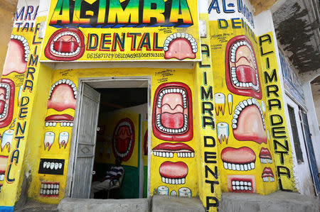 Somali dentist Hassan Ali, 35, sits inside his dental clinic with murals painted on the walls in Hamarweyne district of Mogadishu, Somalia, June 7, 2017. REUTERS/Feisal Omar