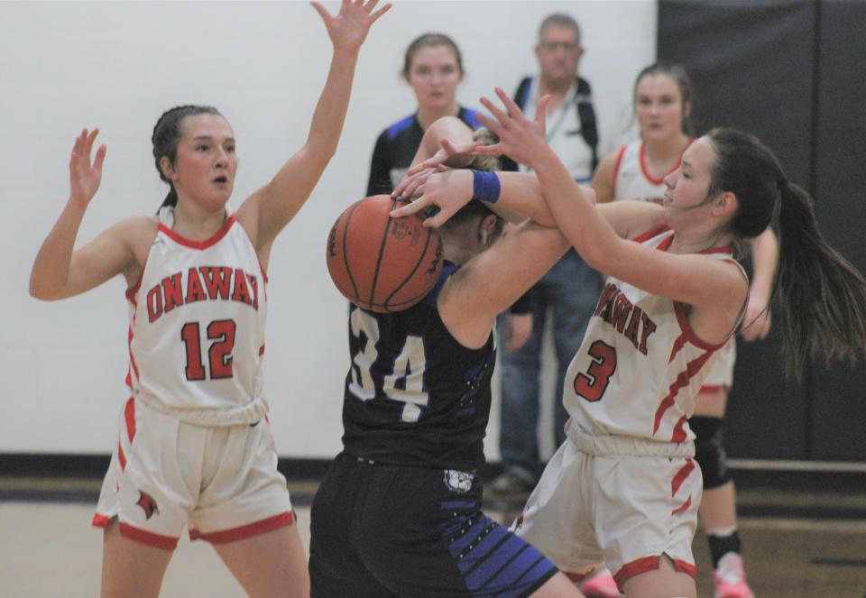 Onaway's Marley Szymoniak (12) and Charlotte Box (3) force Inland Lakes' Molly Monthei (34) into a turnover during the first half of Friday's district clash at Onaway.