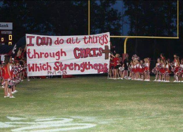 Kountze cheerleaders hold up one of their biblically-related signs — Facebook