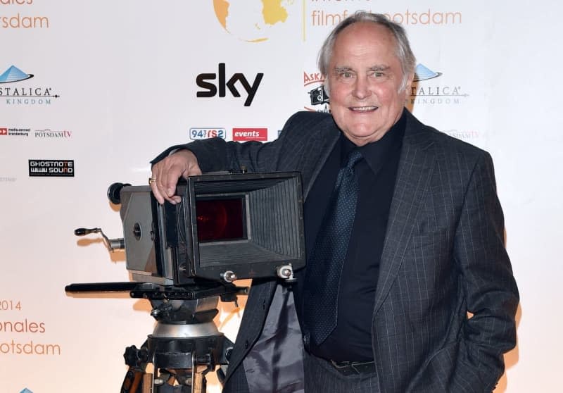 German filmmaker Michael Verhoeven stands in front of an old film camera at the opening of the 1st Potsdam International Film Festival at the Thalia Cinema. Verhoeven died last Monday after a short, serious illness, his family told the German Press Agency in Munich on Friday. Jens Kalaene/dpa