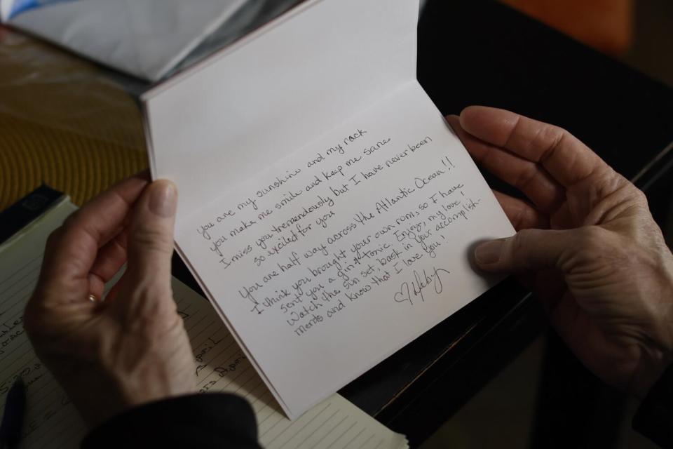 A pair of hands holding a white notecard with a handwritten message