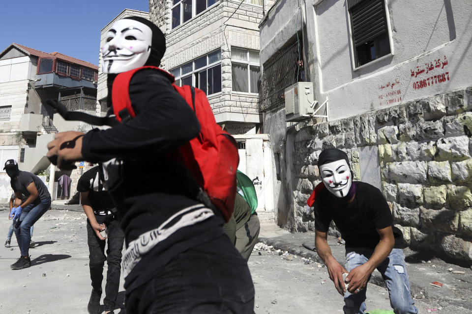 FILE - In this June 28, 2019 file photo, Palestinians clash with Israeli police in Jerusalem's Palestinian neighborhood of Issawiya, a day after a Palestinian was shot and killed by police during a protest in the same neighborhood. Nearly every day for the last nine months Israeli police have stormed into Issawiya in a campaign they say is needed to maintain law and order. Rights groups say that in addition to searching houses and issuing fines, they have detained hundreds of people — some as young as 10, on suspicion of stone-throwing. The operations frequently ignite clashes, with local youths throwing rocks and firebombs. Residents and human rights groups say the provocative raids have created an atmosphere of terror, with parents afraid to let their children play outside. (AP Photo/Mahmoud Illean)