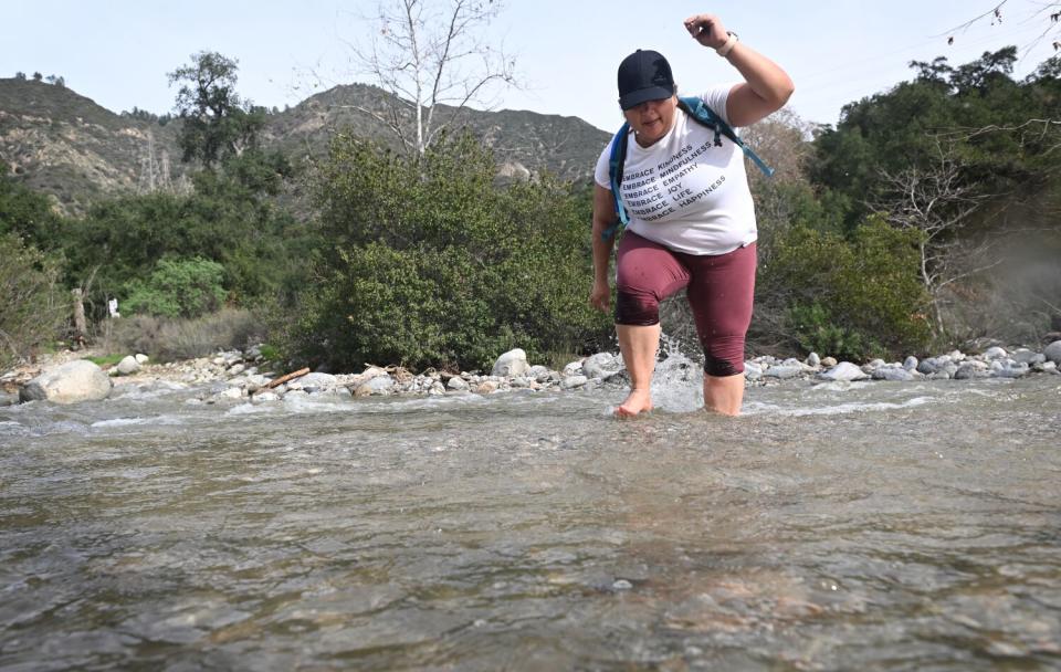 Linda Corella, of San Bernardino, navigates a creek in Eaton Canyon on local hiking trails.